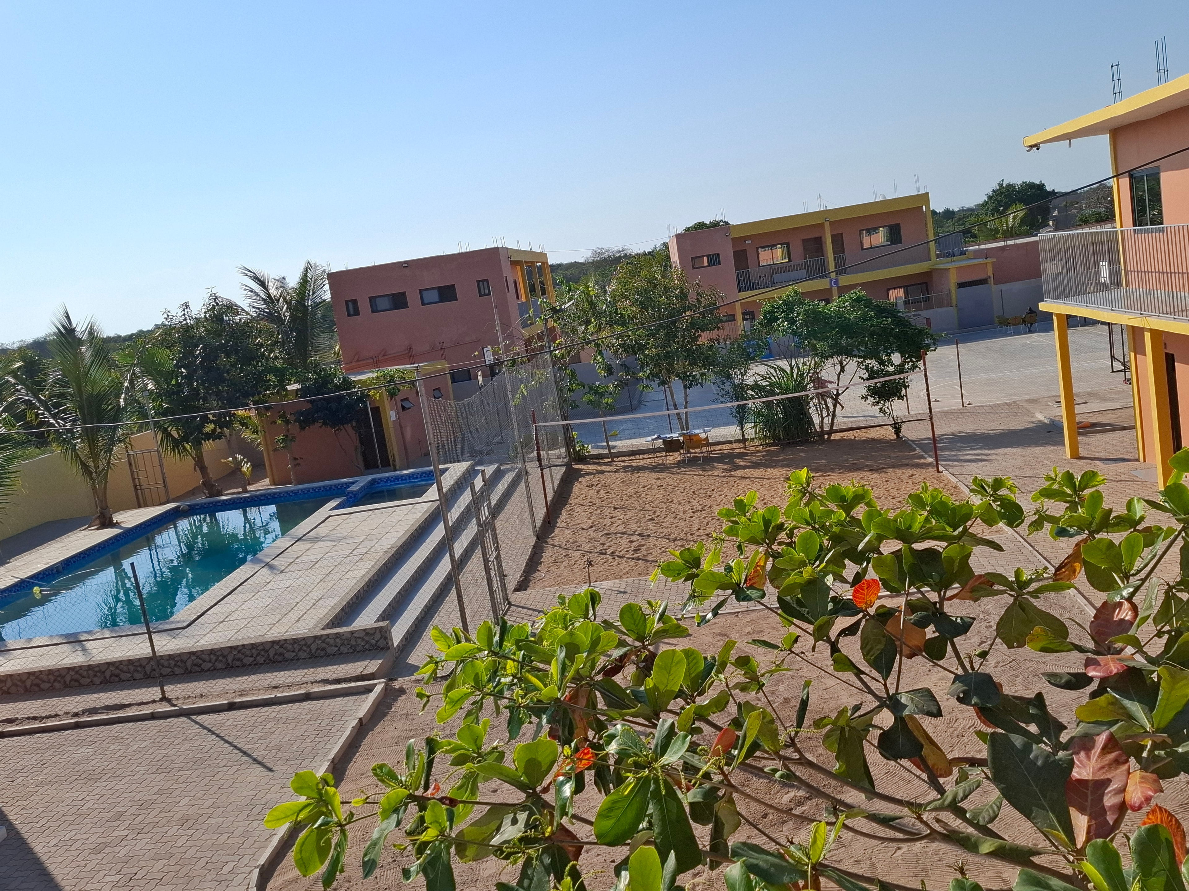 Elevated view of the MGIS swimming pool, outdoor courts and campus buildings