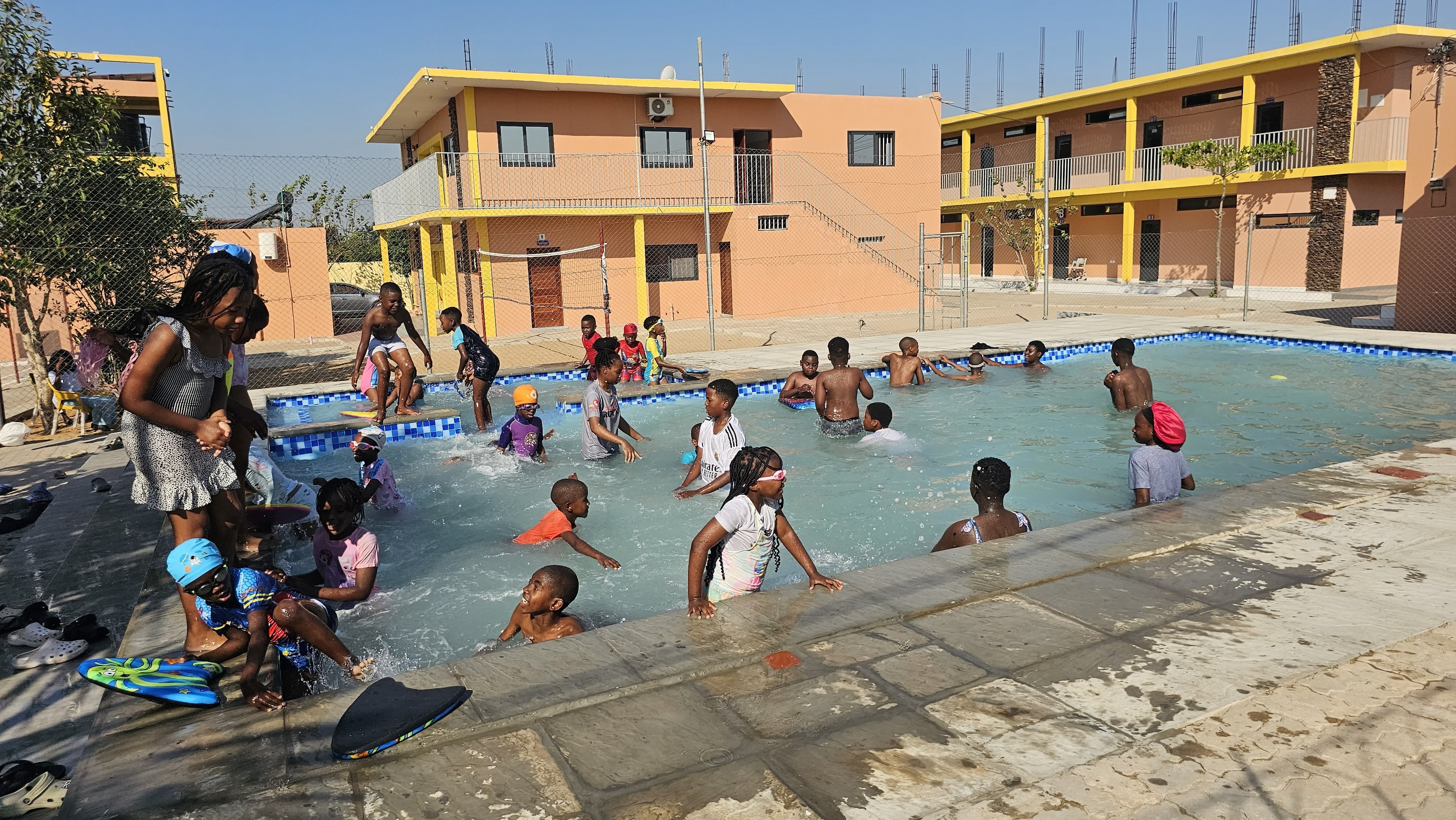 MGIS learners swimming beside the school campus buildings