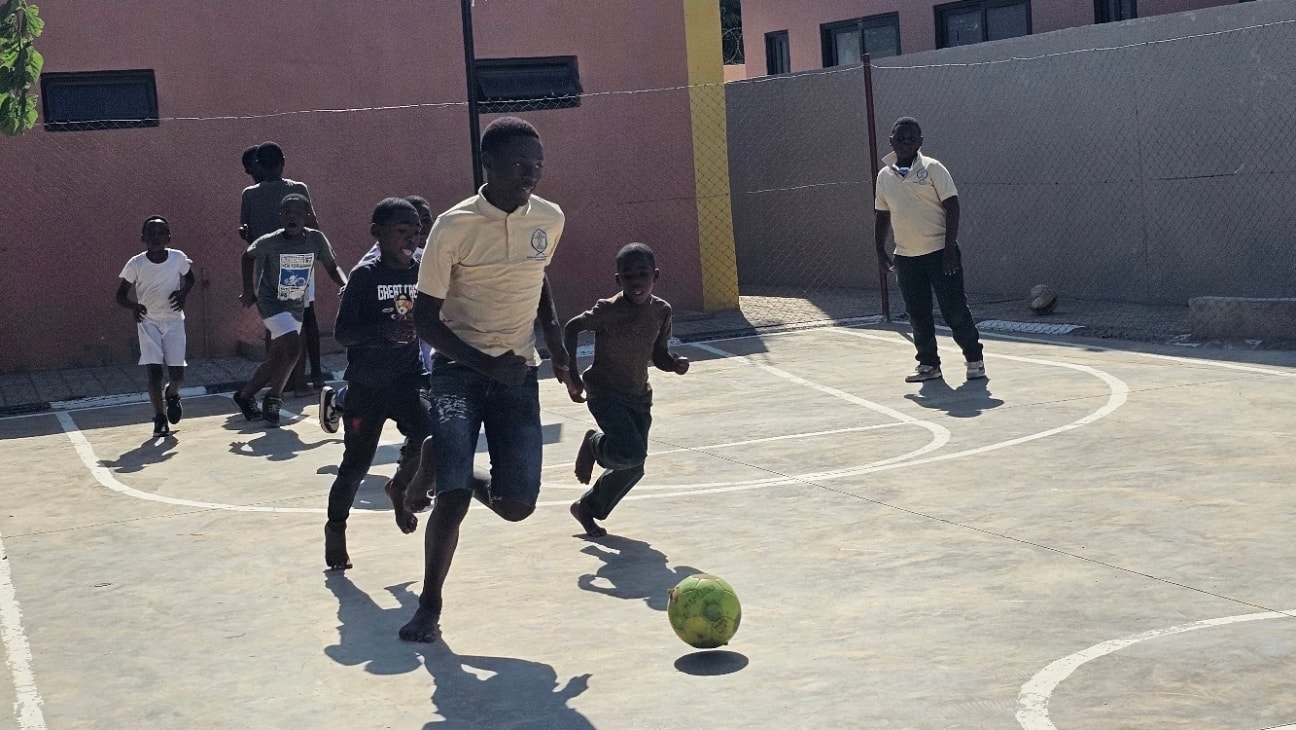 MGIS boys playing football on the school sports court